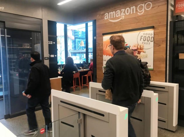 A customer walks out of the Amazon Go store, without needing to pay at a cash register due to cameras, sensors and other technology that track goods that shoppers remove from shelves and bill them automatically after they leave, in Seattle
