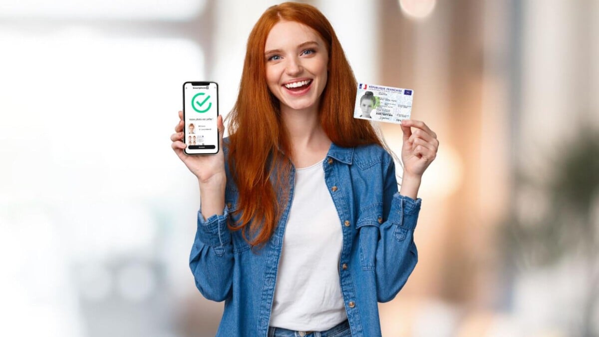 Une jeune femme tenant sa carte d'identité d'une main son smartphone avec l'application Smartphone iD de l'autre.
